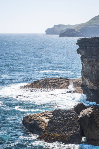 Güneşli bir günde kayalık kıyı şeridinin nefes kesici manzarası - Fotoğraf, Görsel