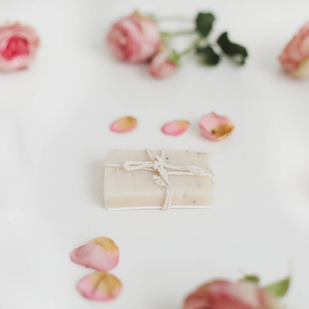 Soap bars with dry roses on white background. Handmade floral soap with rose buds. Natural cosmetics. flat lay, top view - Photo, Image
