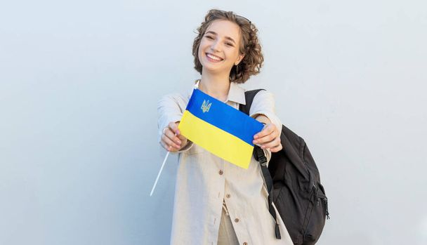 Young happy student woman with the flag of Ukraine and backpack. Independence Day Ukraine.  - Foto, Imagem
