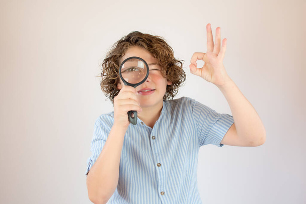 Boy with blue shirt with a magnifying glass - Fotoğraf, Görsel