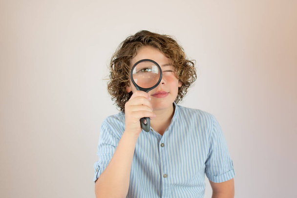 Boy with blue shirt with a magnifying glass - Photo, Image