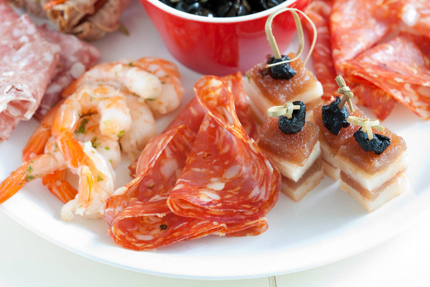 Delicious plate with antipasti snacks such as chorizo and shrimps - Photo, image