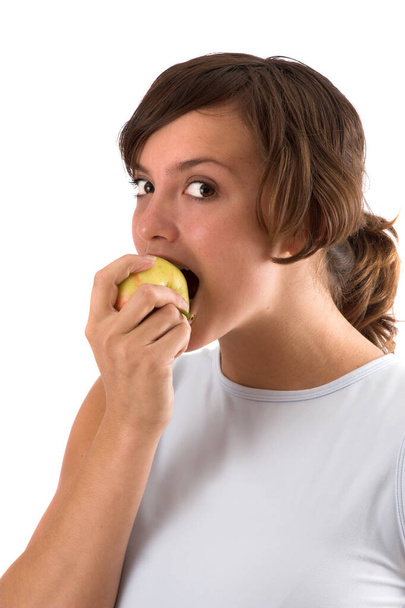 Pretty brunette taking a big bite out of a healthy apple - Photo, Image
