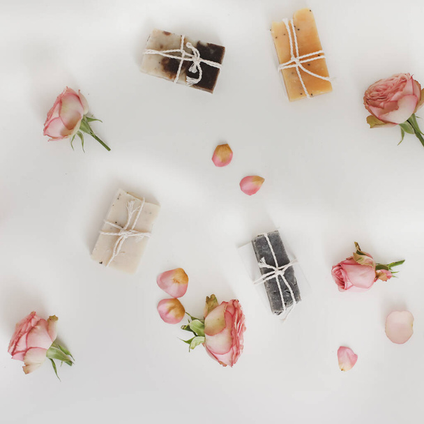 Soap bars with dry roses on white background. Handmade floral soap with rose buds. Natural cosmetics. flat lay, top view - Foto, immagini