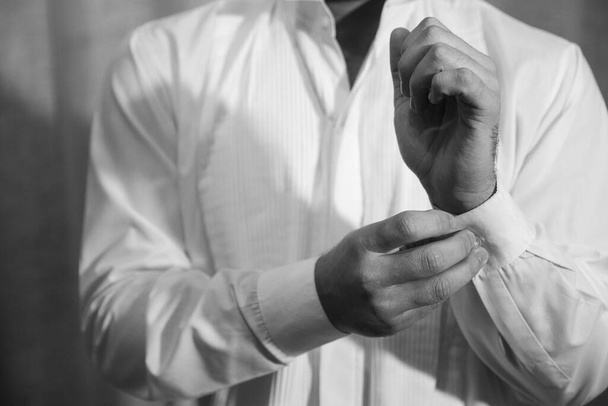 A man fastens a button on a classic shirt - Foto, imagen