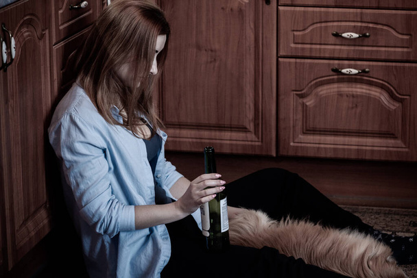 Kobieta ma depresję, problem z alkoholem, siedzi w kuchni z psem - Zdjęcie, obraz