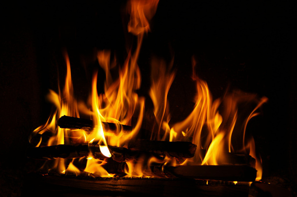 Fogo em uma lareira, chamas de fogo em um fundo preto
 - Foto, Imagem