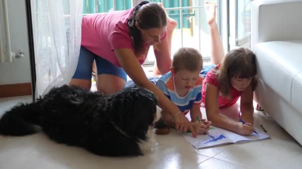 matka z dzieckiem rysują w domu w międzyczasie rozpieszczają psa rodzinnego  - Materiał filmowy, wideo