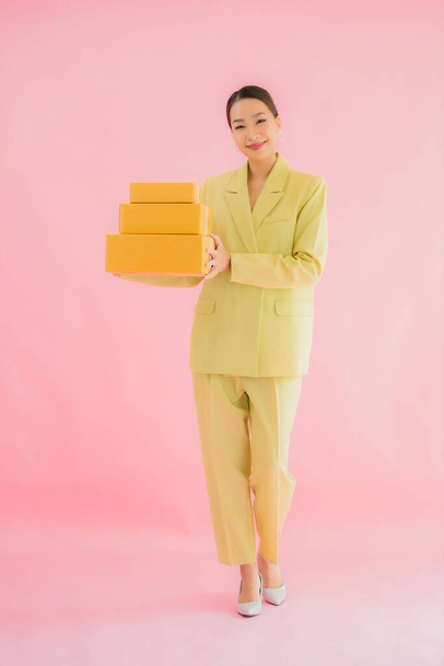 Portrait beautiful young asian woman with parcel box on color background - Фото, зображення
