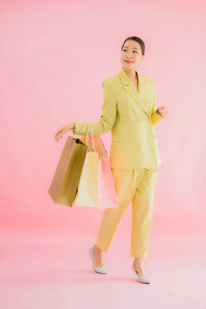 Portret mooie jonge aziatische zakenvrouw met boodschappentas op kleur geïsoleerde achtergrond - Foto, afbeelding