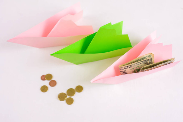 Business concept, 3-paper boats floating along and money on Board, a few coins ahead - Photo, Image