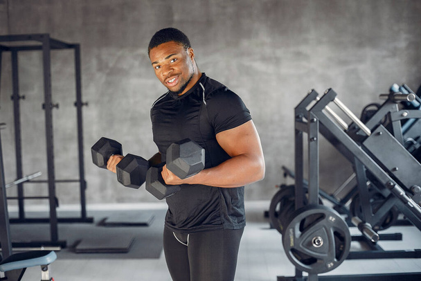 A handsome black man is engaged in a gym - Foto, Imagem