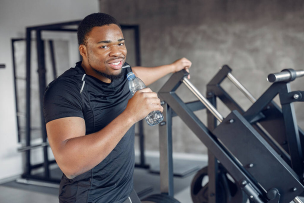 A handsome black man is engaged in a gym - Foto, Imagen