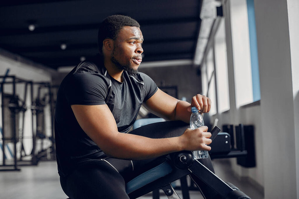 A handsome black man is engaged in a gym - Foto, Imagen
