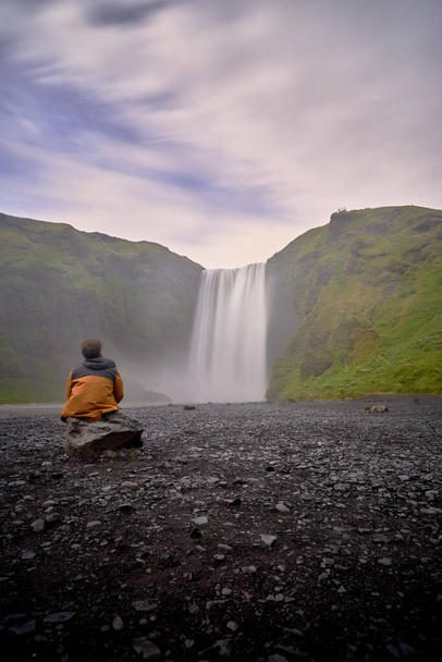 Mann blickt auf die wunderschöne Landschaft des skogafoss Wasserfalls in Island - Foto, Bild