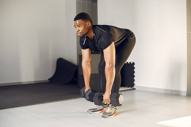 A handsome black man is engaged in a gym - Фото, изображение