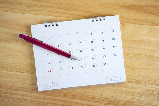 Calendar page with pen on wooden desk table - Zdjęcie, obraz