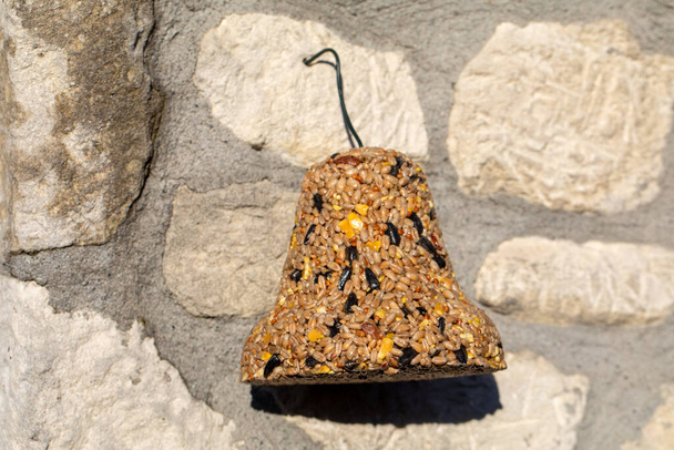 Колокол из различных зерен, деликатес для всех птиц в саду - Фото, изображение