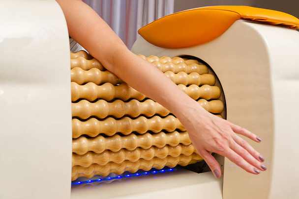 Kadın el masajı yapıyor. Yuvarlak Masaj Makinesi figürü şekillendirmenin bir yoludur. Cilt bakımı, vücut bakımı. modern rahatlama masaj ekipmanı. - Fotoğraf, Görsel