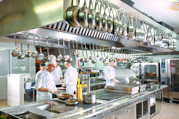 Modern kitchen. Cooks prepare meals on the stove in the kitchen of the restaurant or hotel. The fire in the kitchen - Photo, image