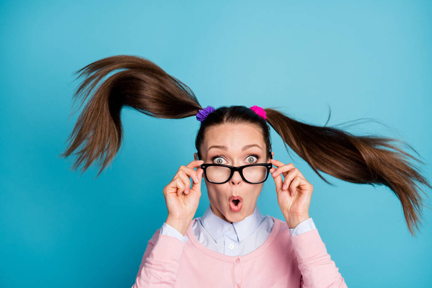 Muotokuva hämmästynyt koulun tyttö näyttää odottamaton valmistumisen tentti uutiset kosketus silmälasit vaikuttunut aliarvostus lentää ilma kulumista hyvä ilme vaatteita eristetty sininen väri tausta - Valokuva, kuva
