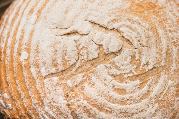 vista de cerca de la corteza de pan recién horneado con harina - Foto, Imagen