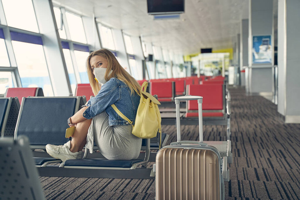 Gelangweilte junge Frau wartet auf ihren Flug - Foto, Bild