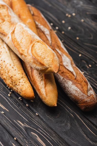 fresh baked baguette loaves on wooden surface - Fotografie, Obrázek