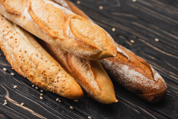 fresh baked baguette loaves on wooden surface - Foto, imagen