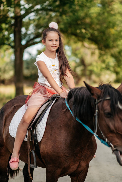 Емоційний контакт з конем. Катання на конях. Дівчина катається на коні влітку
. - Фото, зображення