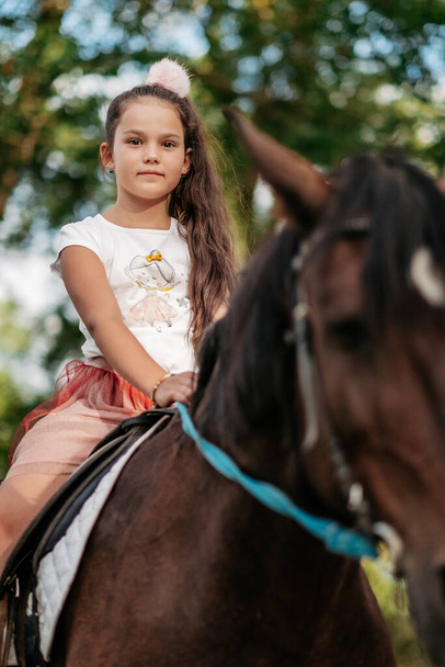 Емоційний контакт з конем. Катання на конях. Дівчина катається на коні влітку
. - Фото, зображення