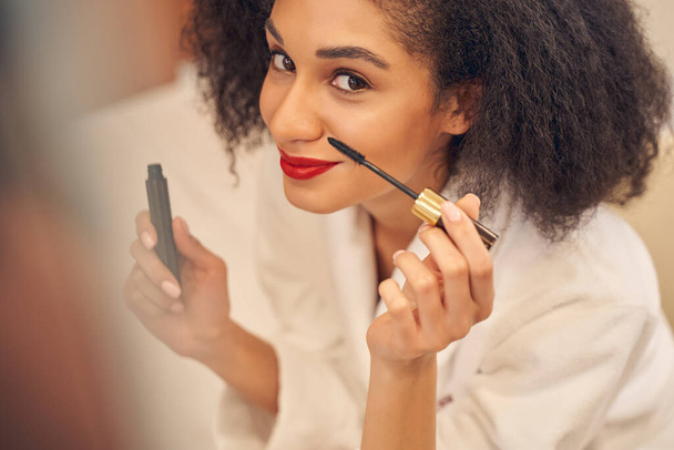 Senhora atraente apreciando o processo de auto-maquiagem - Foto, Imagem