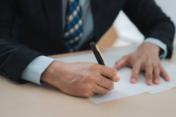 Zamknij biznesmena piszącego lub podpisującego umowę na papierze w biurze - Zdjęcie, obraz