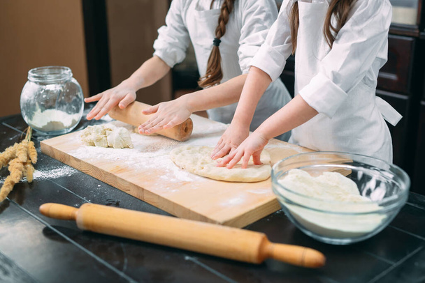 funny girls kids are preparing the dough in the kitchen. - Zdjęcie, obraz