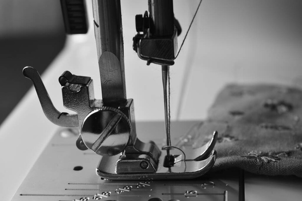 Зображення швейної машини з нитками та голкою. Швейна машина - це машина, яка використовується для зшивання тканини і матеріалів разом з ниткою. Швейні машини були винайдені під час першої промислової революції, щоб зменшити кількість ручної швейної вовни. - Фото, зображення