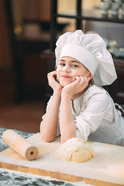 girl kid are preparing the dough in the kitchen. - Foto, afbeelding