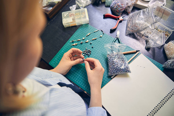 Femme concentrée travaillant avec du matériel de bijouterie en studio - Photo, image
