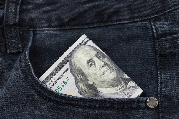 One hundred dollar banknote money in pocket jeans pants background texture. 100 dollar bill close up - Photo, Image