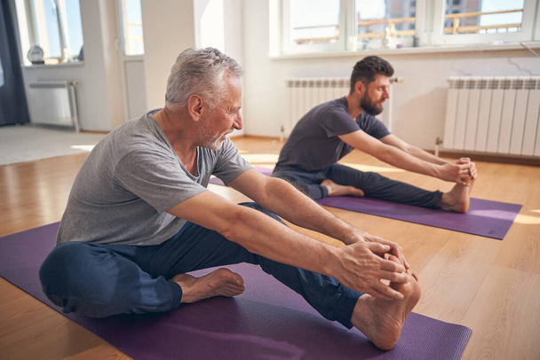 Yogi-Anfänger und sein Trainer praktizieren Yoga - Foto, Bild