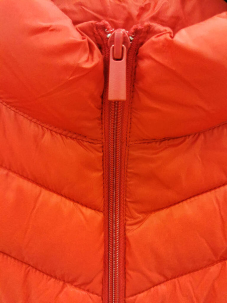 pomarańczowa kurtka puffer tekstury z zamkiem błyskawicznym i runner zbliżenie - Zdjęcie, obraz