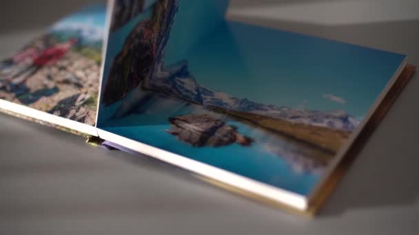Página Volviendo libros de fotos sobre la mesa en casa - Metraje, vídeo