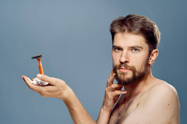 Uomo con rasoio in mano barba viso cura della pelle mattina stile di vita pelle pulita - Foto, immagini