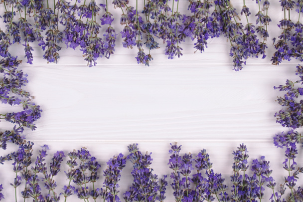 Marco hecho con flores de lavanda fresca sobre fondo de lana lila con copyspace para texto en el centro de la composición. Concepto de aromaterapia y hermoso fondo de verano - Foto, Imagen