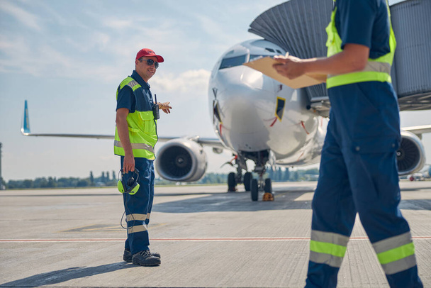 Flugzeugwartungsleiter im Gespräch mit einem Mechaniker - Foto, Bild