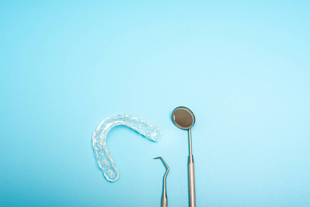 Alineador dental transparente junto al espejo del dentista, espacio para copiar. - Foto, imagen