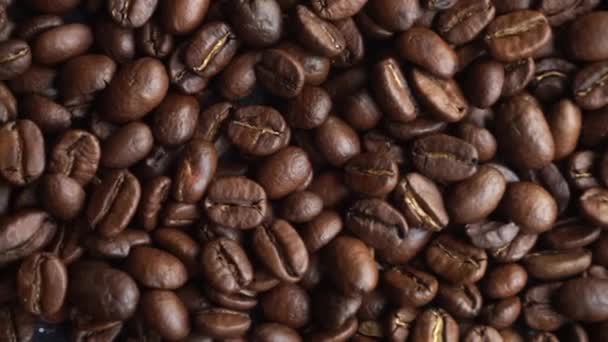 Fondo de granos de café. Elaboración y tostado de granos de café para una bebida. Vista superior mo lento - Imágenes, Vídeo
