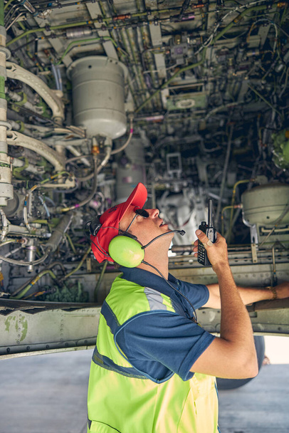 Hombre con un walkie-talkie inspeccionando un avión - Foto, Imagen