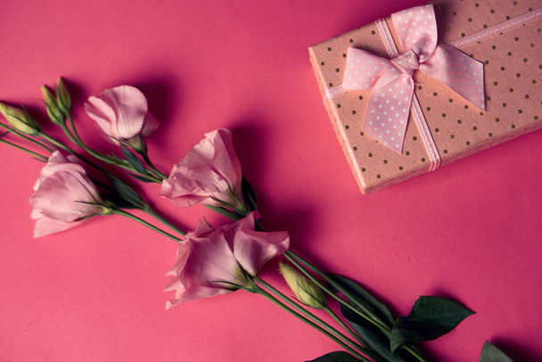 Scatola regalo con fiori primaverili vacanze sfondo rosa vista ritagliata - Foto, immagini