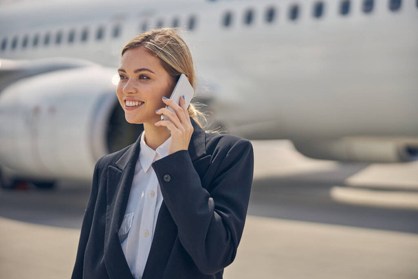 Kobieta ze smartfonem w airdrome - Zdjęcie, obraz