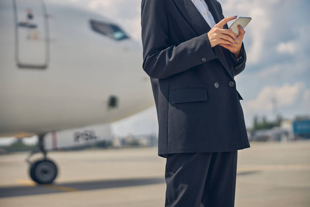 Стильна бізнес-леді стоїть в аеропорту
 - Фото, зображення